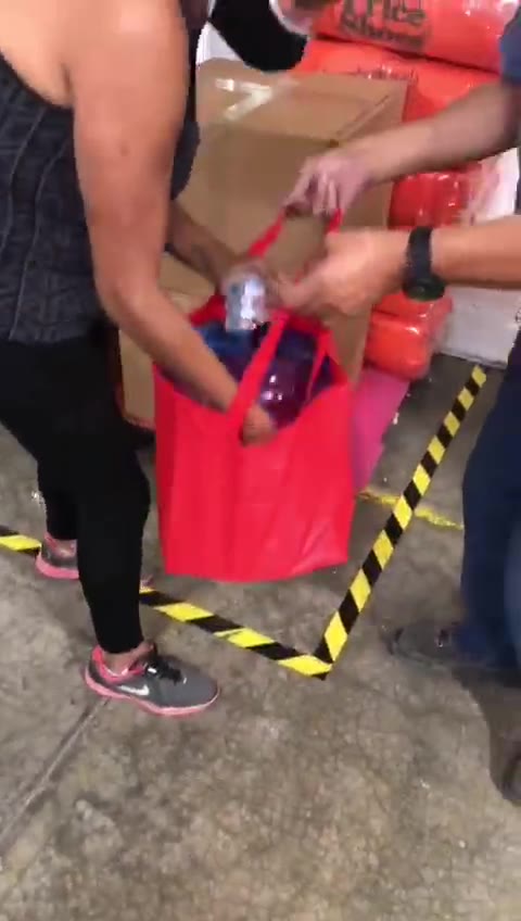 Bolsa roja de 90 g de nuestra producción cargando un garrafón de 20 litros